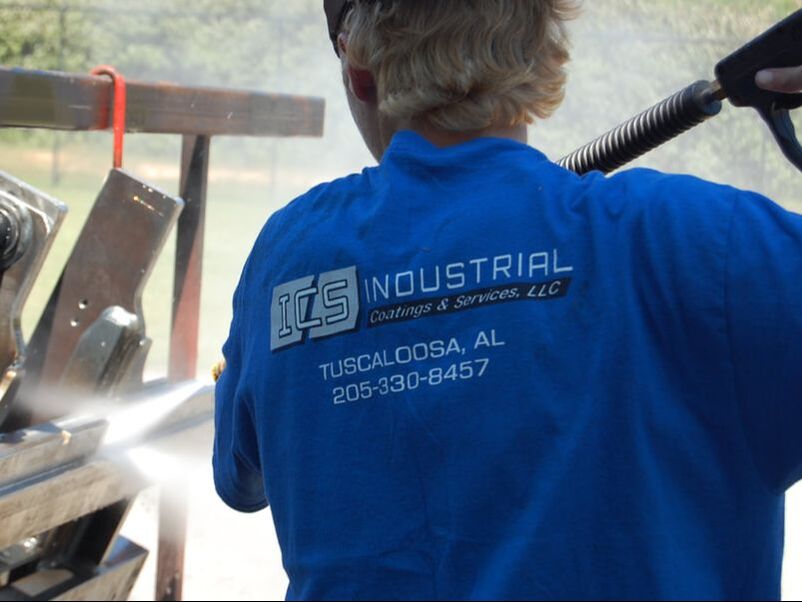 ICS crew member sandblasting and prepping metal parts